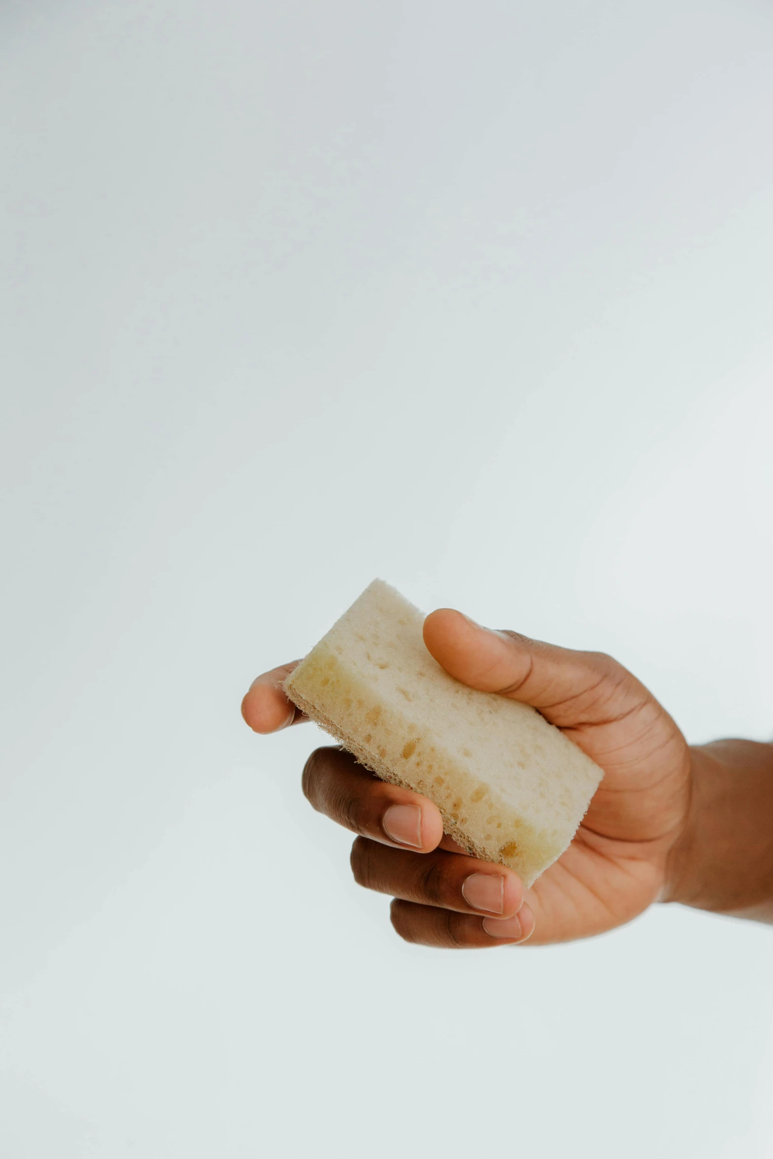 a person holding a piece of bread in their hand, by Daniel Seghers, unsplash, minimalism, carved soap, clean shaved, diverse, brushed