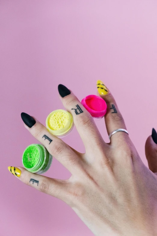 a close up of a person's hand with a ring on it, by Julia Pishtar, pop art, macaron, yellow makeup, play-doh, black nails