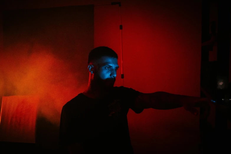 a man standing in front of a red light, in a dark room, profile image, halloween, lightshow