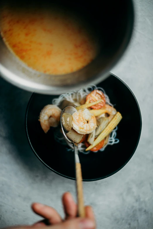 a person holding a spoon over a bowl of soup, a portrait, inspired by Tan Ting-pho, unsplash, prawn, thumbnail, sparkling, grey