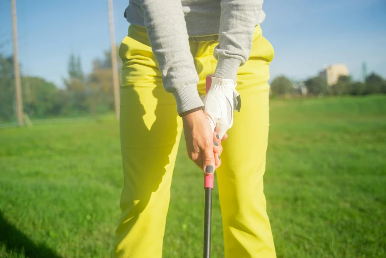 a woman in yellow pants holding a golf club, unsplash, corrected hands, thumbnail, 1 2 9 7, medium distance shot