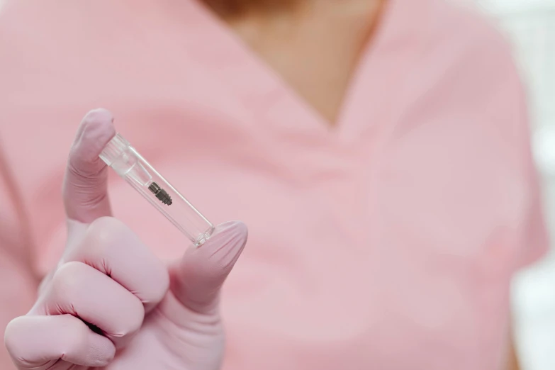 a close up of a person in a pink shirt, holding a syringe, background image, microchip, nurse scrubs