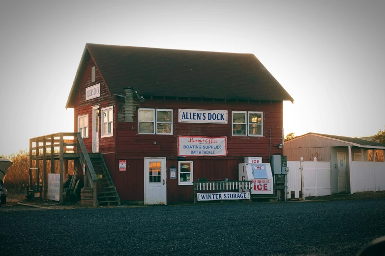 a red building sitting on the side of a road, by Allan Brooks, seafood in preserved in ice, golden hour photograph, alice, located in a wizard's shop