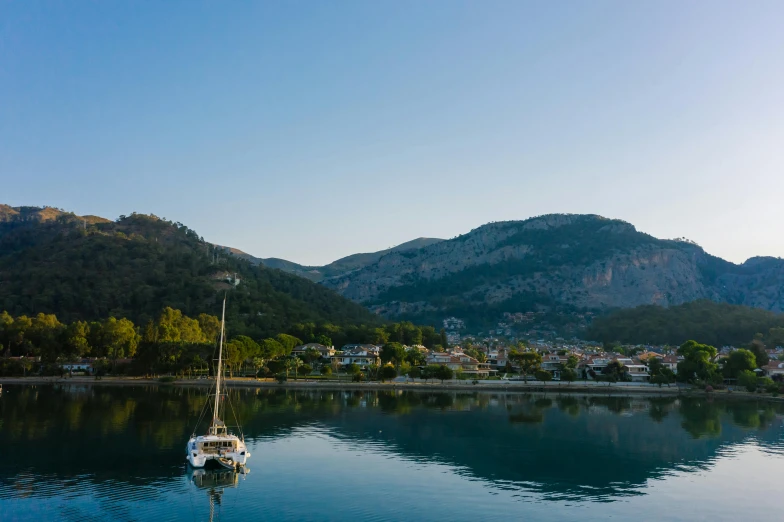 a boat floating on top of a body of water, by Niko Henrichon, pexels contest winner, hurufiyya, southern european scenery, picton blue, alana fletcher, sailboat