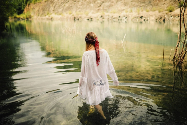 a woman in a white dress standing in a body of water, cottagecore hippie, promo image, colour photo, drenched clothing