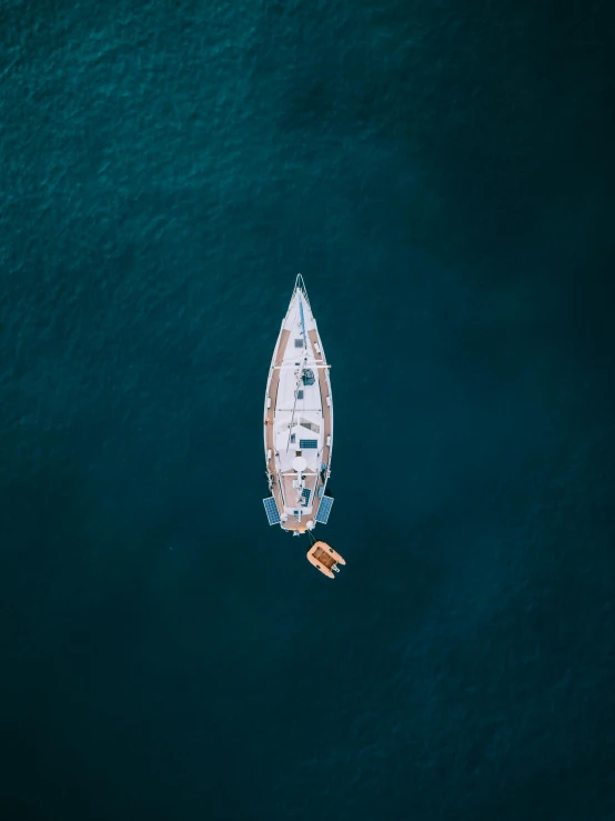 a boat floating in the middle of a body of water, by Sebastian Spreng, pexels contest winner, relaxing on a yacht at sea, top down camera angle, award winning cinematic, deep colour