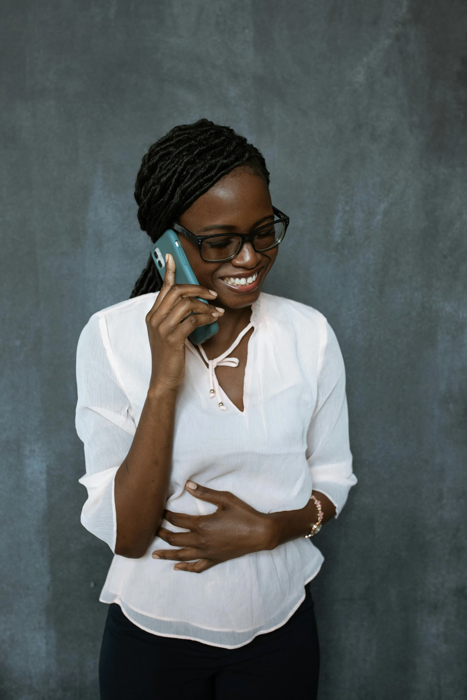 a woman in a white shirt talking on a cell phone, by Chinwe Chukwuogo-Roy, trending on unsplash, teal studio backdrop, embracing, 15081959 21121991 01012000 4k, grey skinned