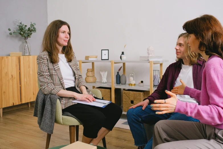 two women sitting in chairs talking to each other, unsplash, two buddies sitting in a room, low quality photo, realistic »