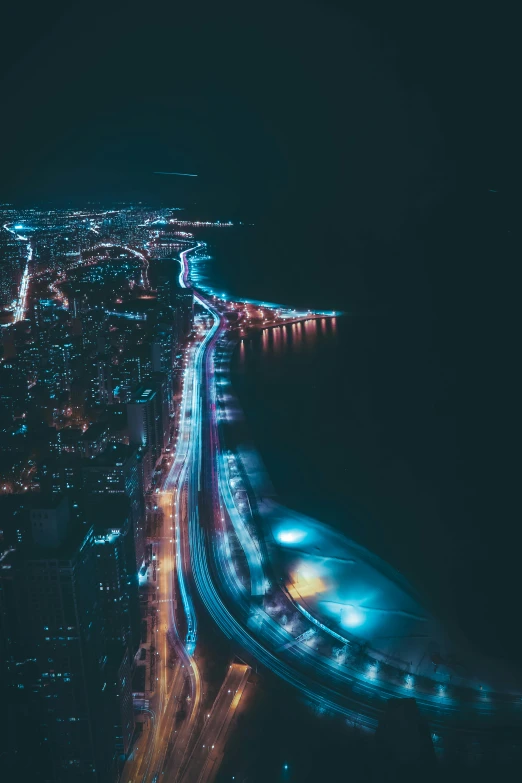 an aerial view of a city at night, pexels contest winner, coastline, modern chicago streets, teal lights, long exposure photo