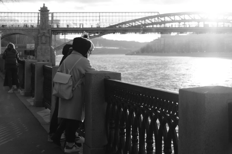 a black and white photo of people on a bridge, a black and white photo, romanticism, moscow, golden hour photo, gazing at the water, tourist photo