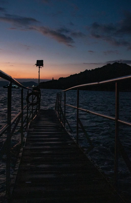 a dock in the middle of a body of water, in the evening, 8k 28mm cinematic photo, lookout tower, back towards camera