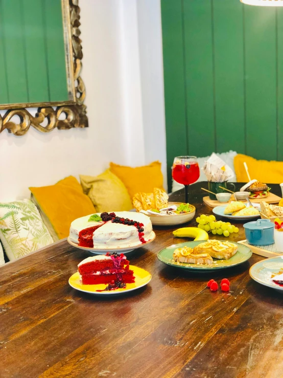 a wooden table topped with plates of food, happening, 🎀 🗡 🍓 🧚, green and yellow, profile image, cosy atmosphere