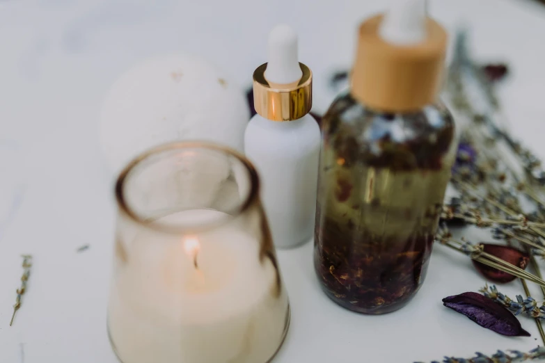 a close up of a candle on a table, bottles, skincare, profile image, random