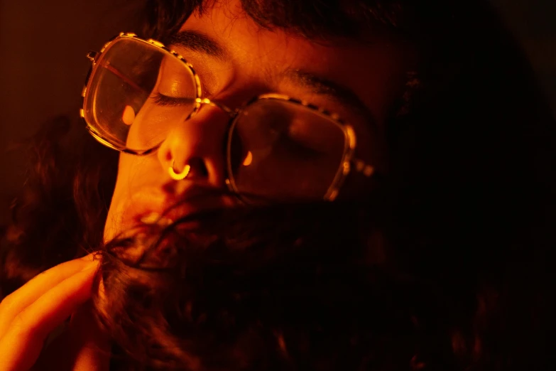 a close up of a person with glasses on, inspired by Elsa Bleda, fire lit, seventies cinestill, sleepy, jayison devadas