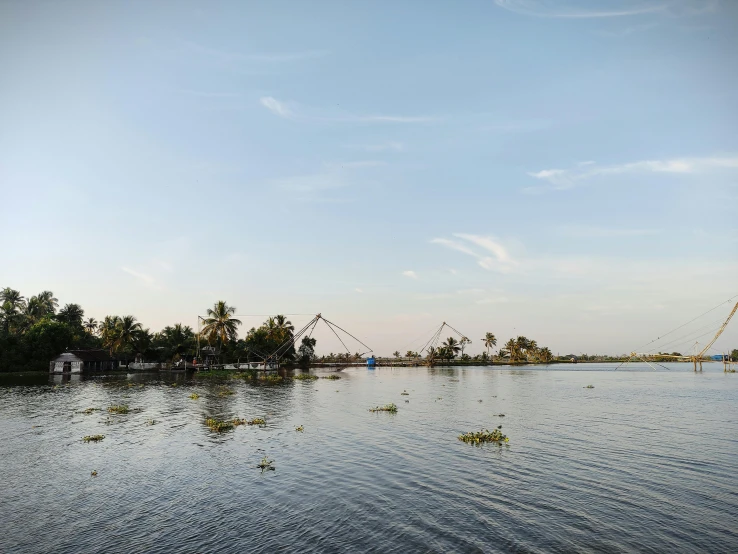 a body of water with a bridge in the background, hurufiyya, with kerala motifs, conde nast traveler photo, skies behind, swings