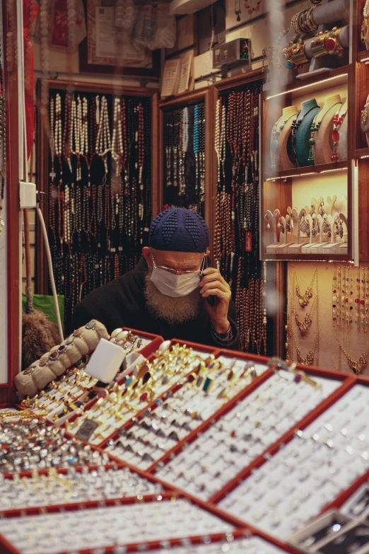 a man wearing a face mask in a jewelry store, by Nathalie Rattner, trending on unsplash, cloisonnism, taken in 1 9 9 7, muslim, wet market street, working