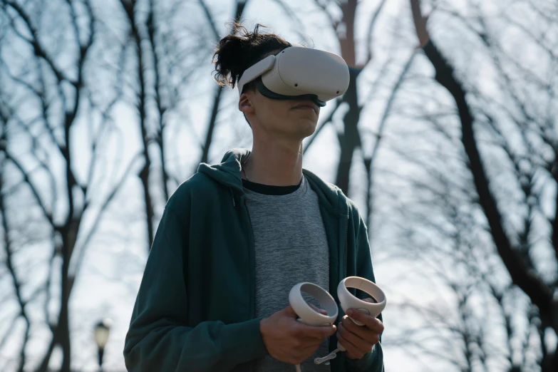 a man holding a video game controller in his hands, unsplash, renaissance, oculus quest 2, with a park in the background, floating headsets, casually dressed