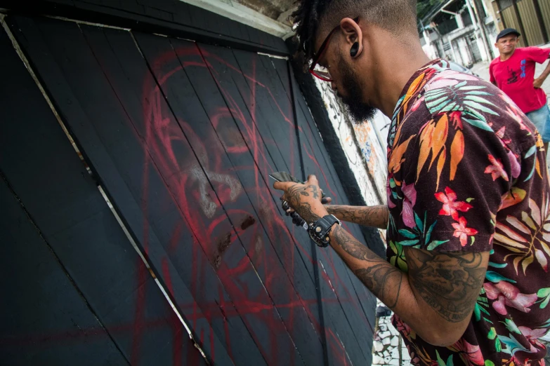 a man painting graffiti on the side of a building, an airbrush painting, by João Artur da Silva, pexels contest winner, panel of black, : jaiye farrell art, it has a red and black paint, aaron horkey