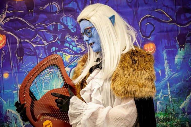 a woman dressed in costume holding a harp, an album cover, inspired by Louis Grell, furry art, blue-skinned elf, youtube thumbnail, portrait mode photo, halloween