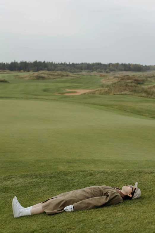 a man laying on the ground on a golf course, by Jesper Knudsen, majestic dunes, slight overcast, sleeping, ox