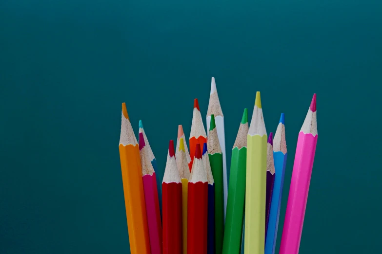 a group of colored pencils sitting next to each other, a child's drawing, by Rachel Reckitt, unsplash, blue background colour, * colour splash *, viewed from below, schools