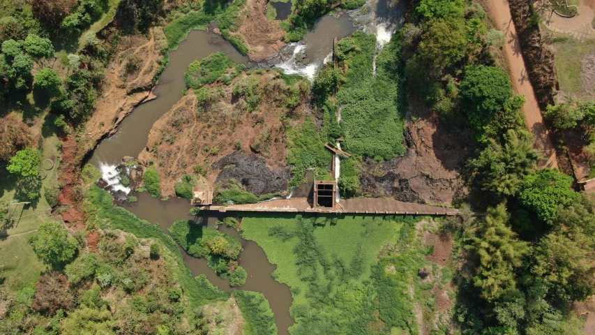 an aerial view of a bridge over a river, by David Palumbo, hurufiyya, water fall, partially operational, promo image, mongezi ncaphayi