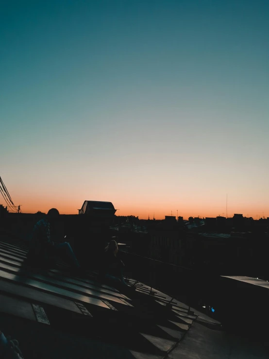 the sun is setting on the roof of a building, a photo, pexels contest winner, happening, calm night. over shoulder shot, trending on vsco, sky line, today\'s featured photograph 4k