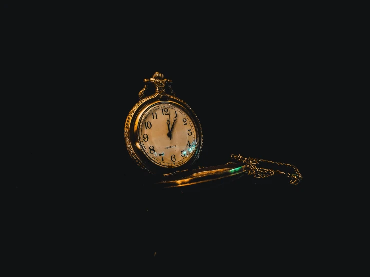 a close up of a pocket watch on a chain, an album cover, by Elsa Bleda, unsplash, with a black background, background image, profile pic