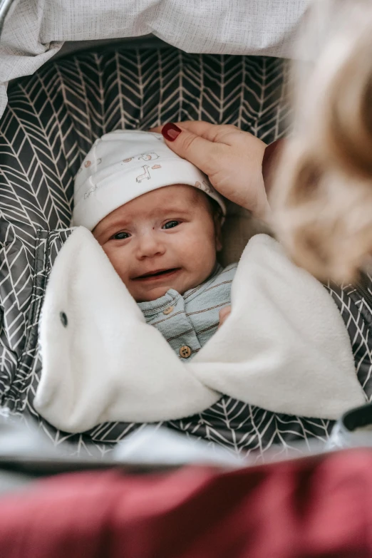 a woman holding a baby in a stroller, pexels contest winner, hibernation capsule close-up, boy with neutral face, patterned, grey