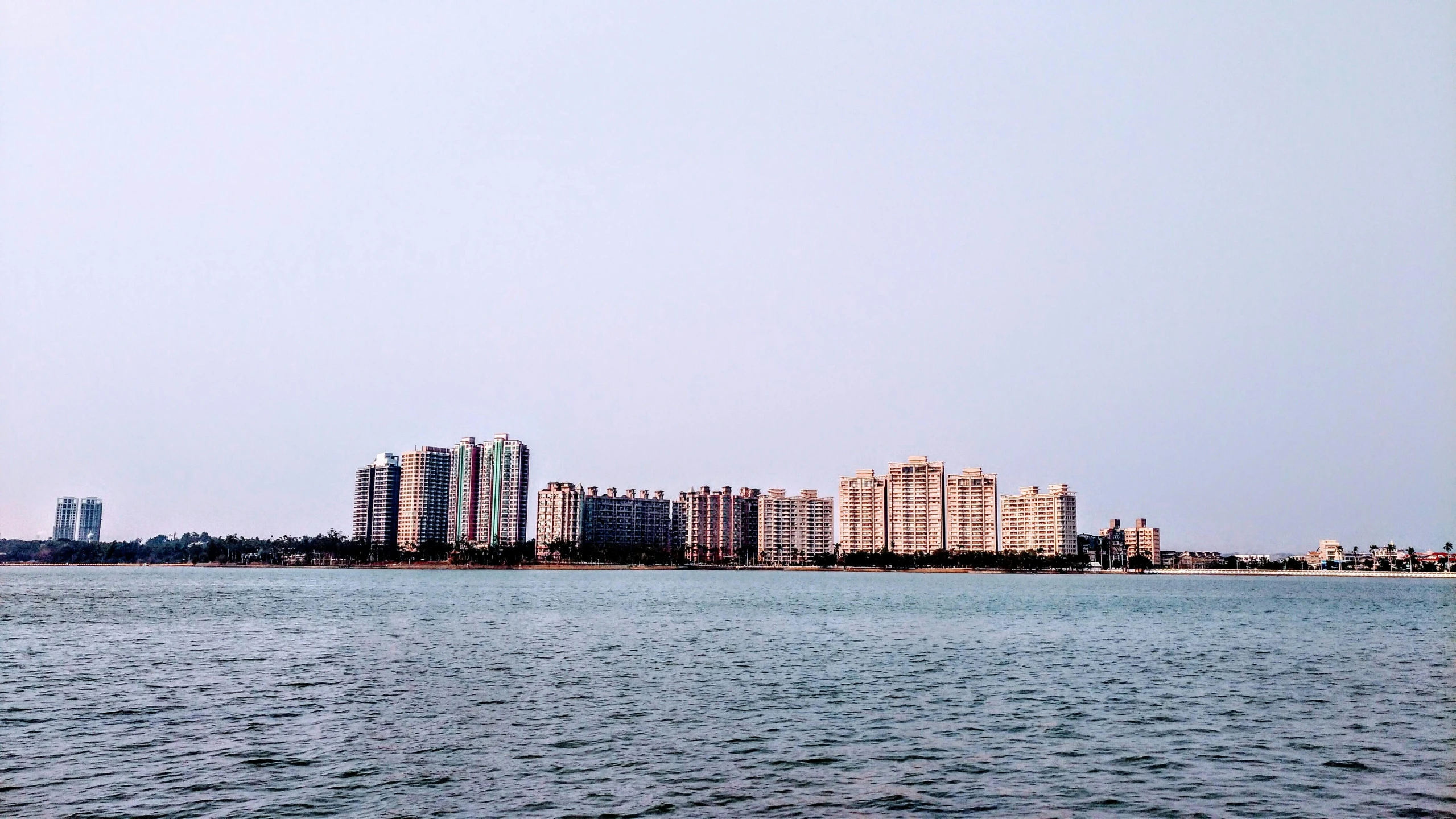 a large body of water with buildings in the background, inspired by Zhang Kechun, pexels contest winner, residential area, view from the sea, city park, where a large