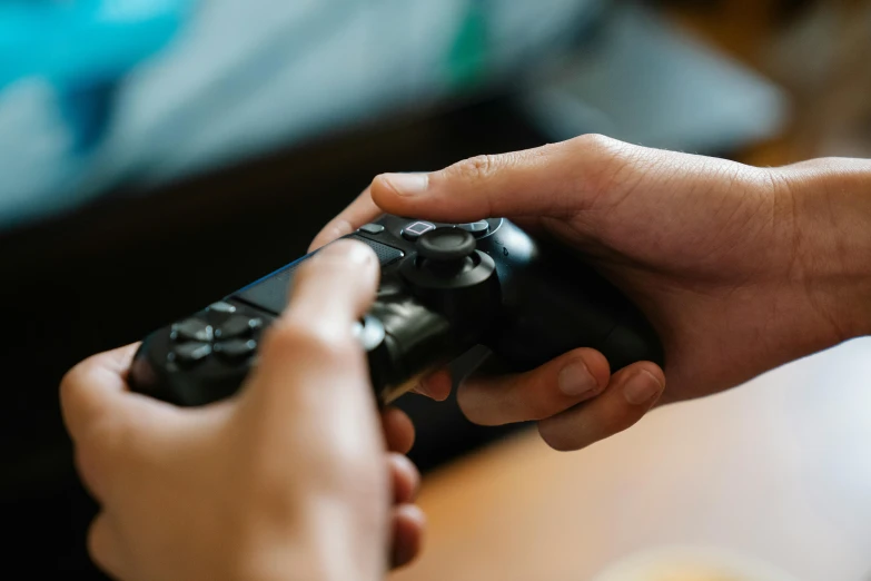 a close up of a person holding a video game controller, hand on table, thumbnail, ps4, twins playing video games