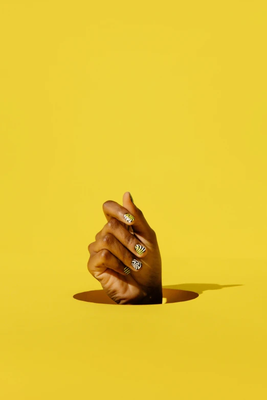 a person's hand reaching out of a hole, an album cover, inspired by Barkley Hendricks, trending on pexels, hyperrealism, yellow gemstones, unclipped fingernails, studio shot, ring lit