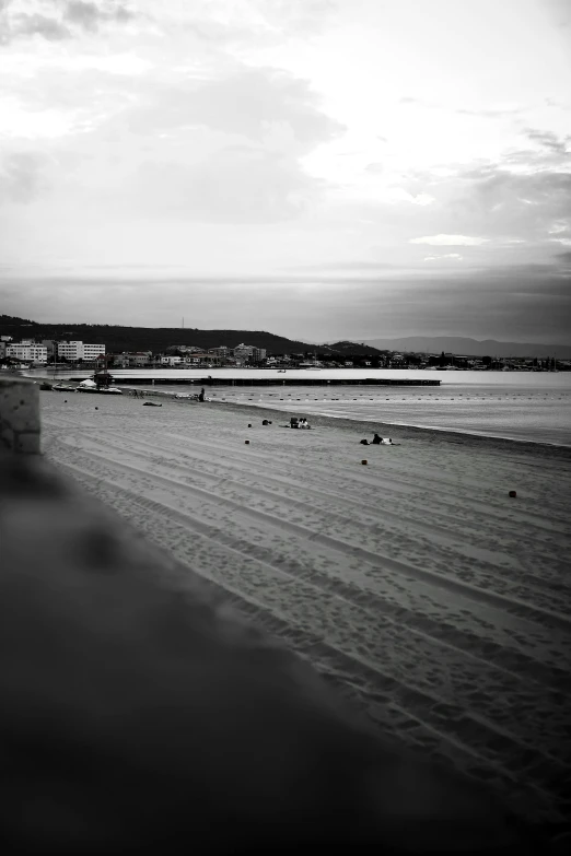 a black and white photo of a beach, inspired by Max Dupain, unsplash, renaissance, japan shonan enoshima, low quality photo, cityscape, in spain