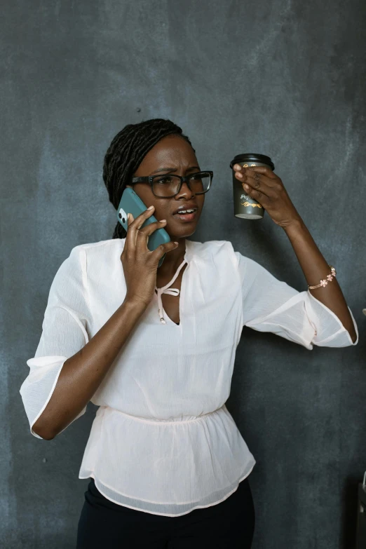 a woman standing in front of a blackboard talking on a cell phone, trending on pexels, afrofuturism, holding a tin can, wearing black rimmed glasses, an elegant, distress