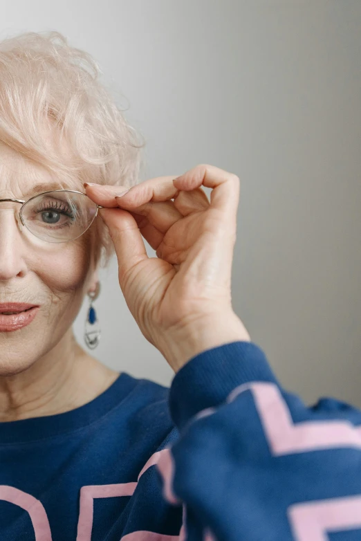 an older woman putting on a pair of glasses, trending on pexels, photorealism, tall thin frame, wearing silver hair, half image, sapphire