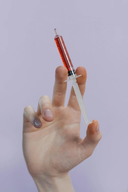 a person holding a syet in their hand, holding a syringe, red and purple, textured base ; product photos, transparent skin