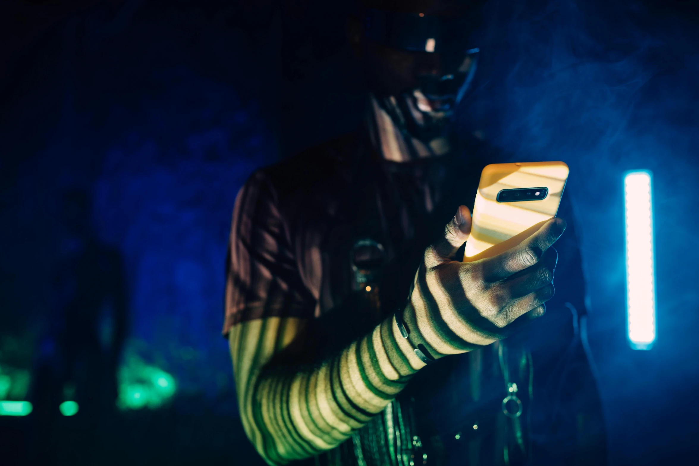 a close up of a person holding a cell phone, inspired by Elsa Bleda, afrofuturism, at a rave, murky lighting, slide show, high quality image