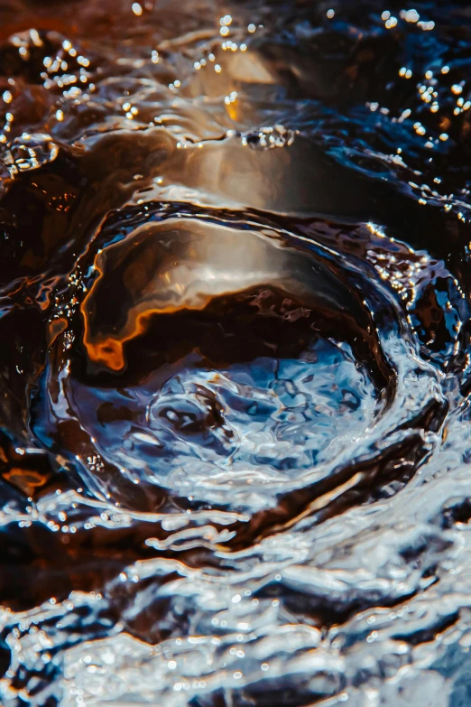 a close up of a brown substance in a body of water, by Jacob Toorenvliet, complex vortex, cold brew coffee ), dark blue water, ring of fire