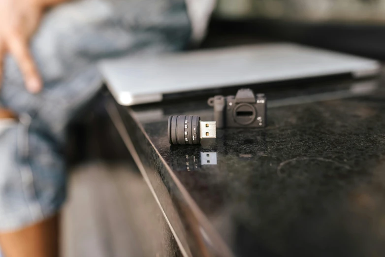 a camera sitting on top of a table next to a laptop, hasselblad film bokeh, usb ports, 33mm photograph, modeled