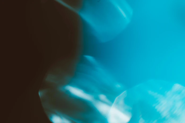 a blurry photo of a person holding a toothbrush, a microscopic photo, inspired by Elsa Bleda, unsplash, light and space, cyan dimensional light, (abstract), liquid shadows engulf, ( ( abstract ) )