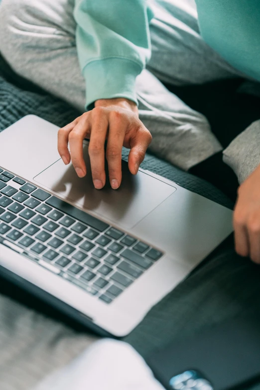 a person sitting on a bed using a laptop, pexels, wearing a grey hooded sweatshirt, sleek hands, thumbnail, avatar image