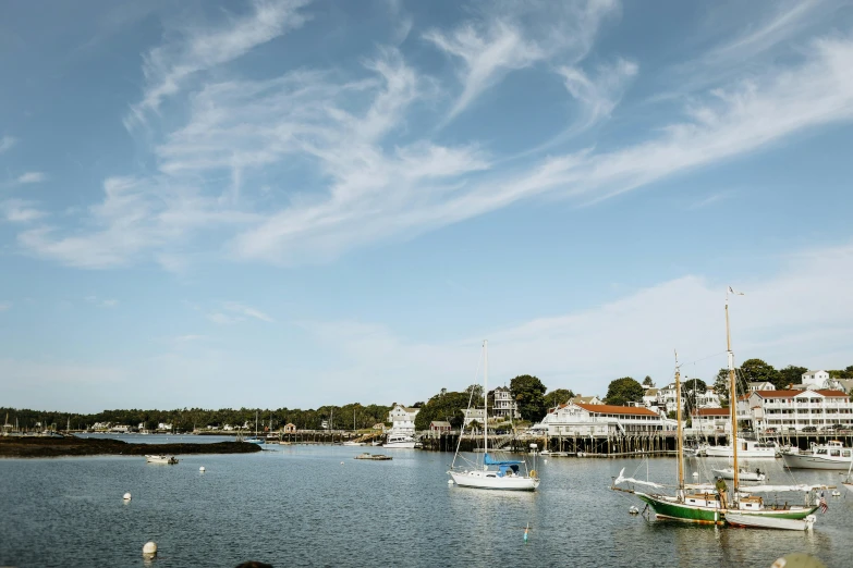 a group of boats floating on top of a body of water, by David Brewster, pexels contest winner, new england architecture, upon a peak in darien, peter hurley, coastal