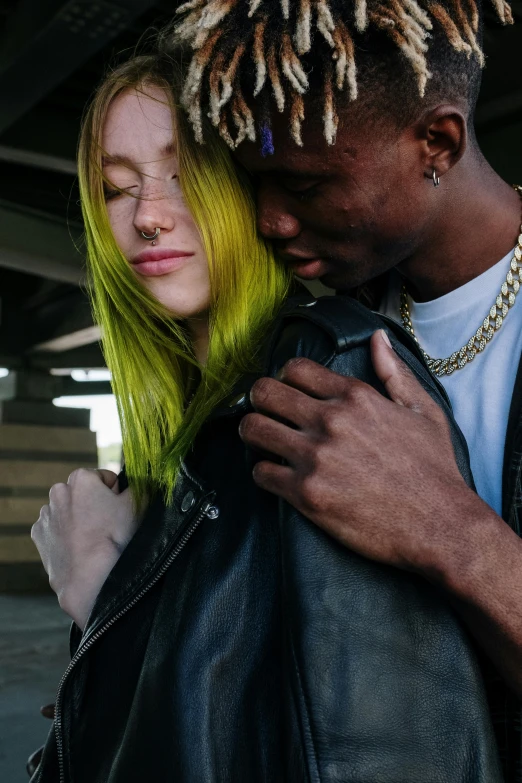 a man and a woman standing next to each other, a colorized photo, inspired by Elsa Bleda, trending on pexels, bright green hair, black teenage boy, lesbian embrace, charcoal and yellow leather