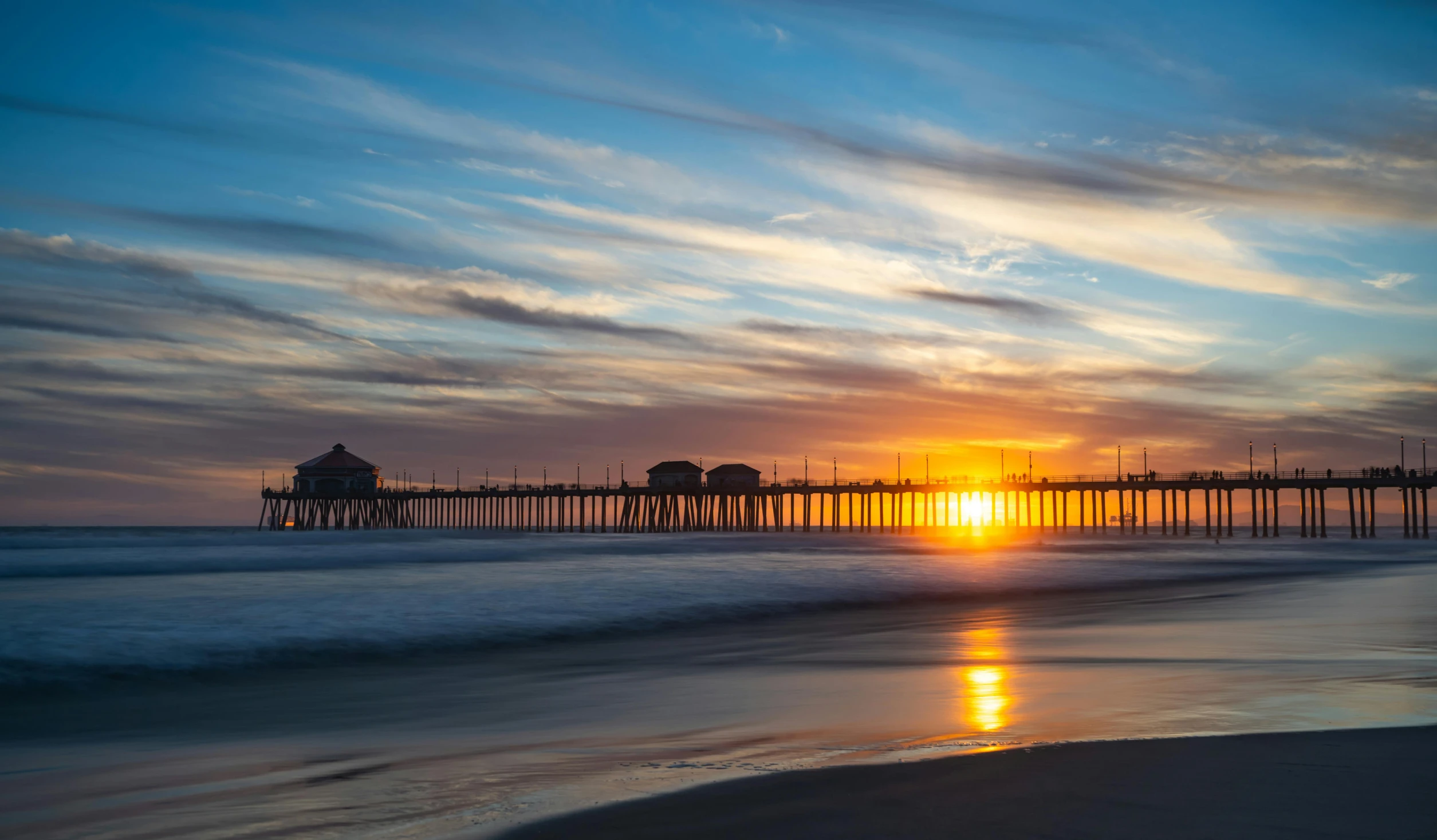 a sunset at the beach with a pier in the background, by Jacob Burck, pexels contest winner, renaissance, los angeles ca, profile image, sunset panorama, multiple suns