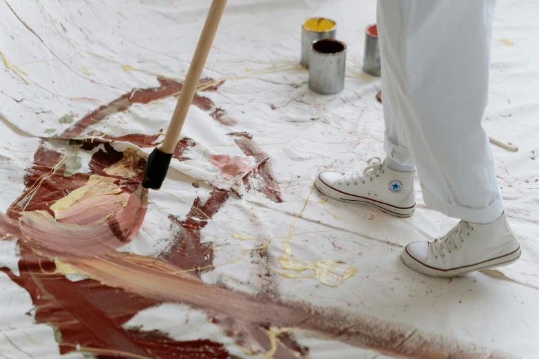a person standing on top of a floor covered in paint, a hyperrealistic painting, inspired by Julian Schnabel, trending on pexels, action painting, red brown and white color scheme, holding a paintbrush, painting on silk, white