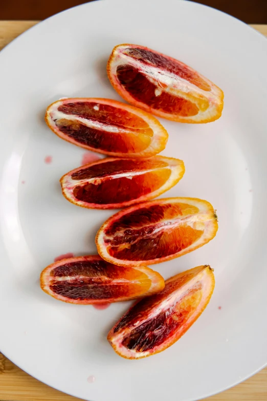 a white plate topped with sliced blood oranges, reddit, full frame image, made of glazed, organs, very crispy