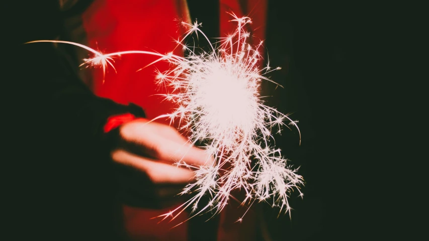 a person holding a sparkler in their hand, a stipple, pexels, red and white neon, instagram post, magnesium, in 2 0 1 5