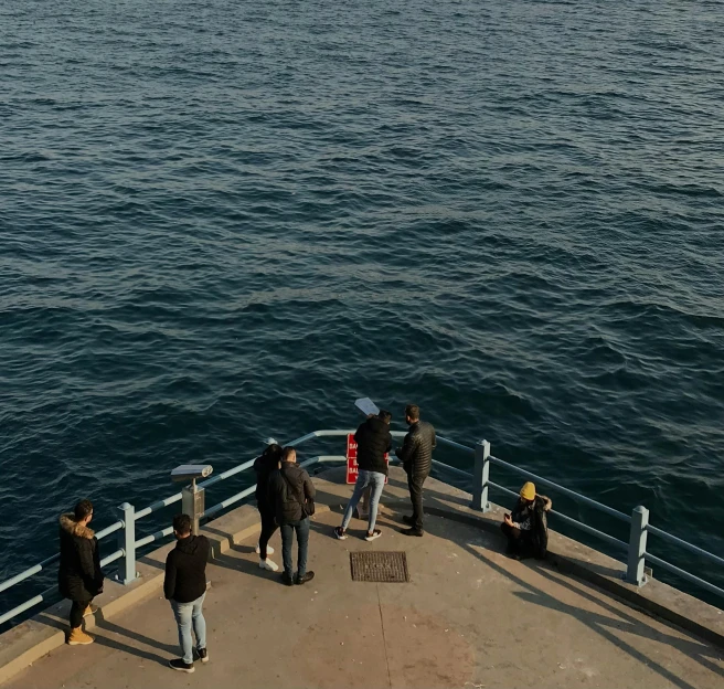 a group of people standing on top of a boat, by Niko Henrichon, pexels contest winner, happening, black sea, tehran, observation deck, 5 feet distance from the camera