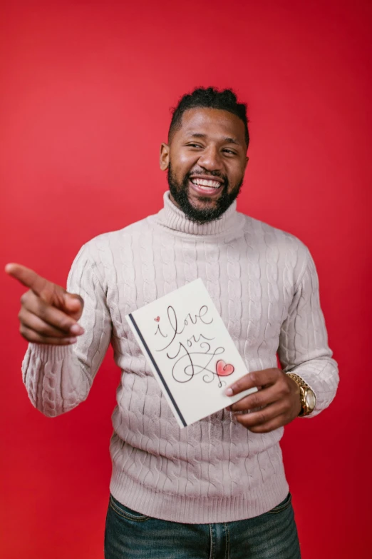 a man standing in front of a red background holding a book, ray lewis, loveable guy, instagram photo, high resolution product photo