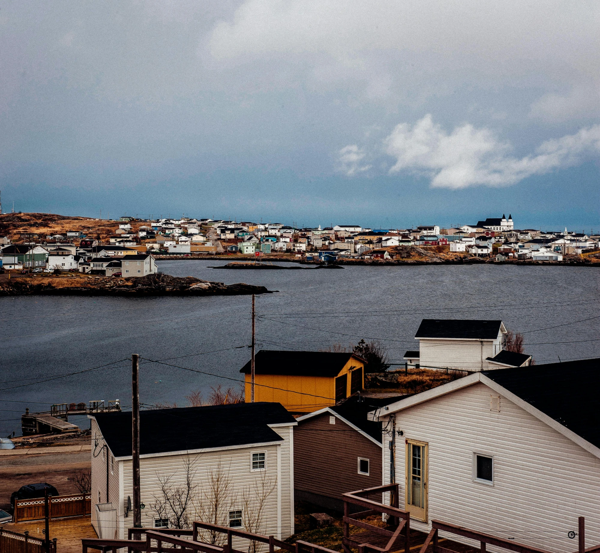 a number of houses near a body of water, by Carey Morris, pexels contest winner, les nabis, inuk, urban view in the distance, slide show, vibrant but dreary